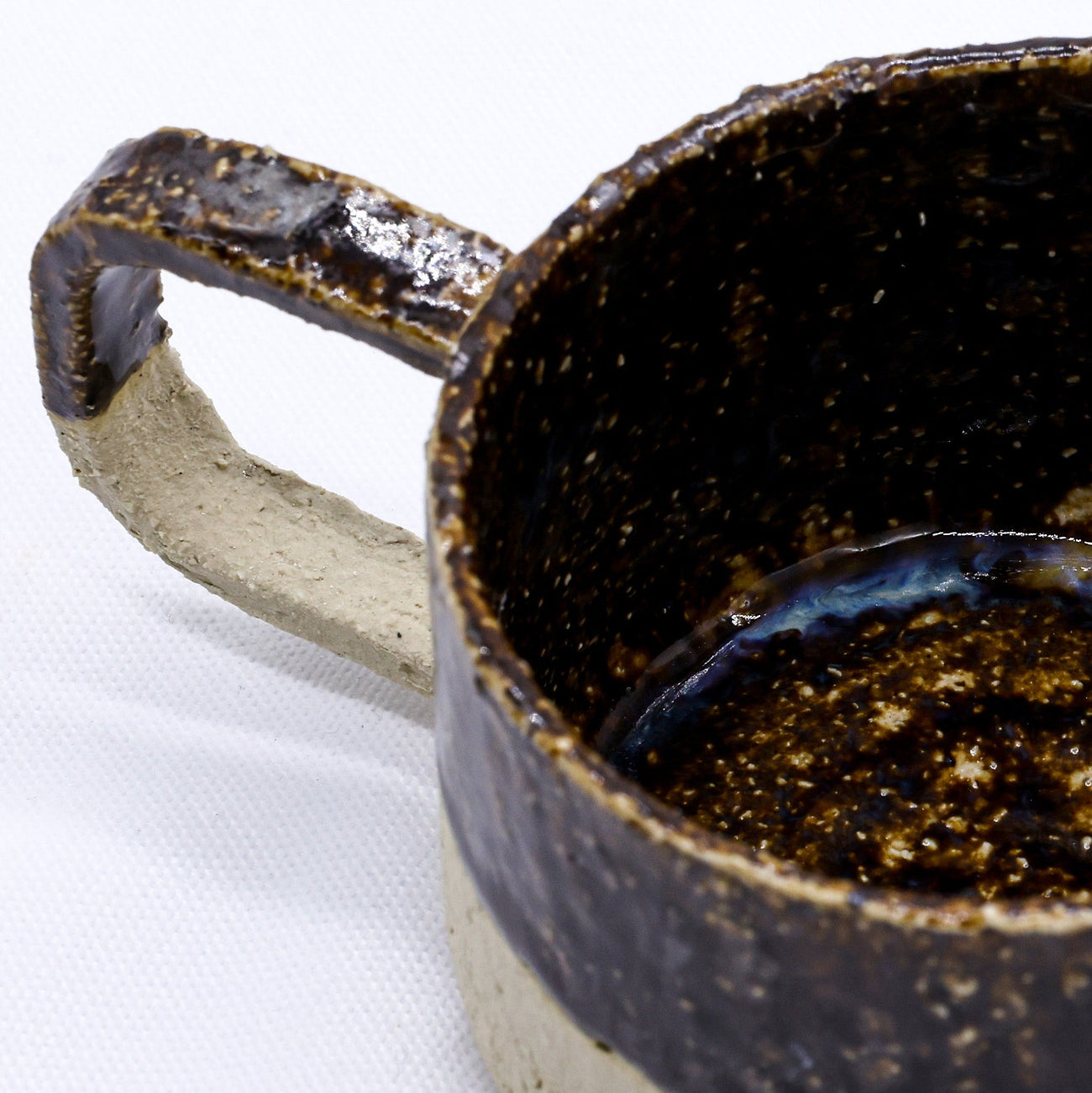 Close-up of a ceramic mug with a dark brown glaze