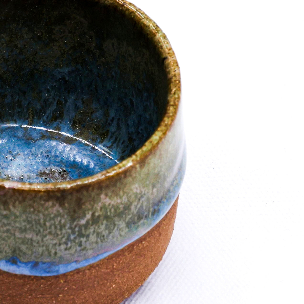 Close-up of a ceramic cup with a textured surface on a white background