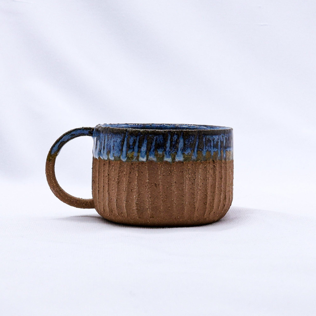 Ceramic mug with blue rim on a white background
