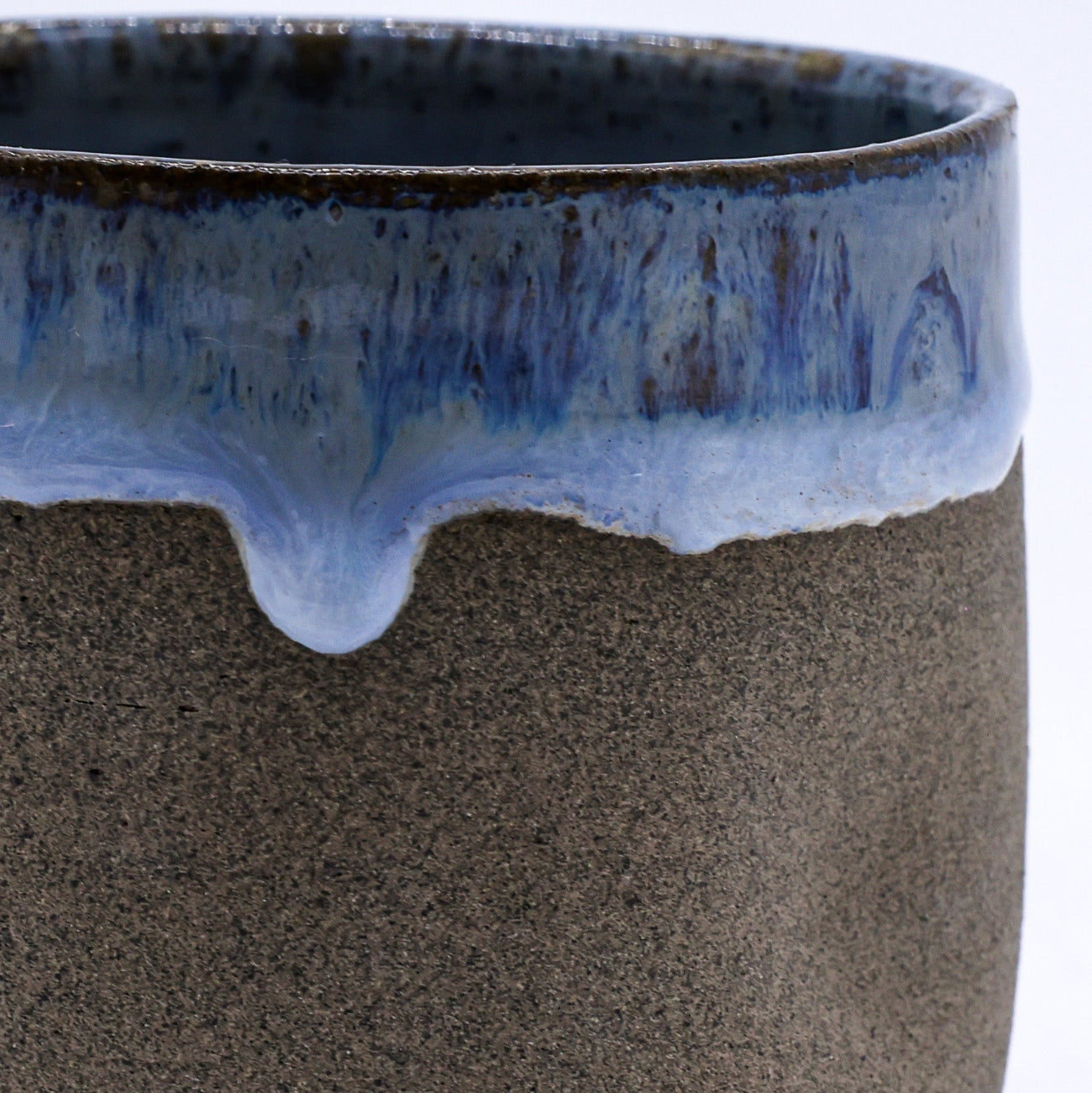 Ceramic pot with blue glaze on a white background