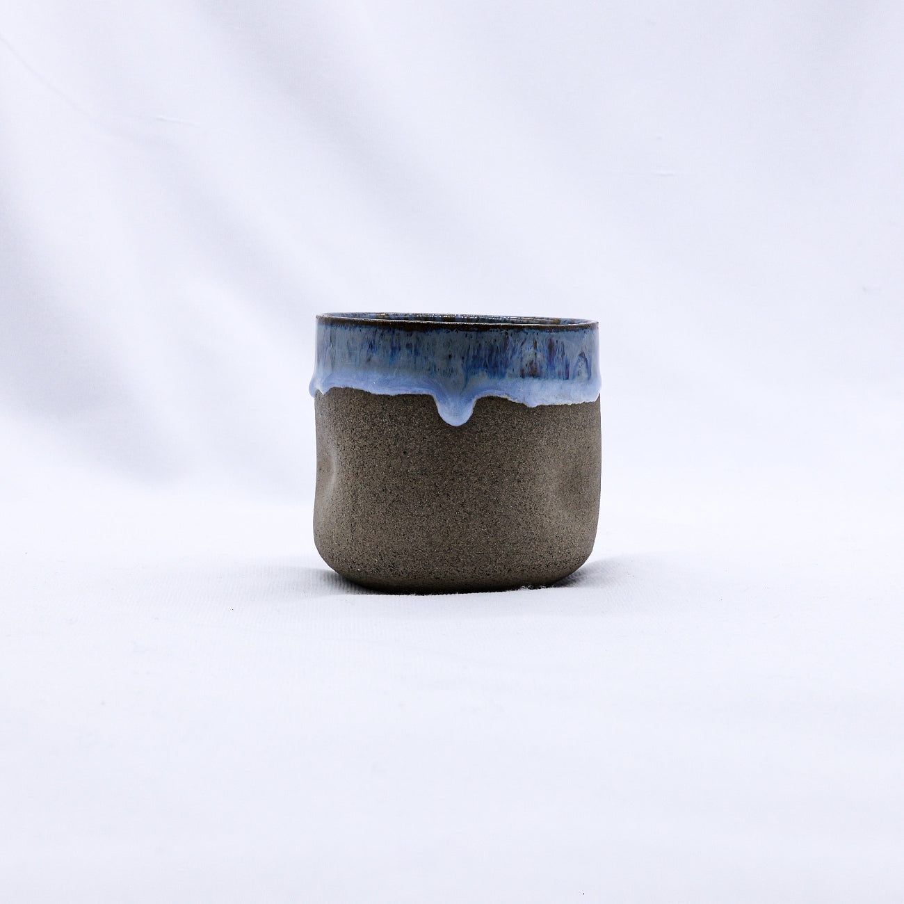 Ceramic cup with blue rim on a white background