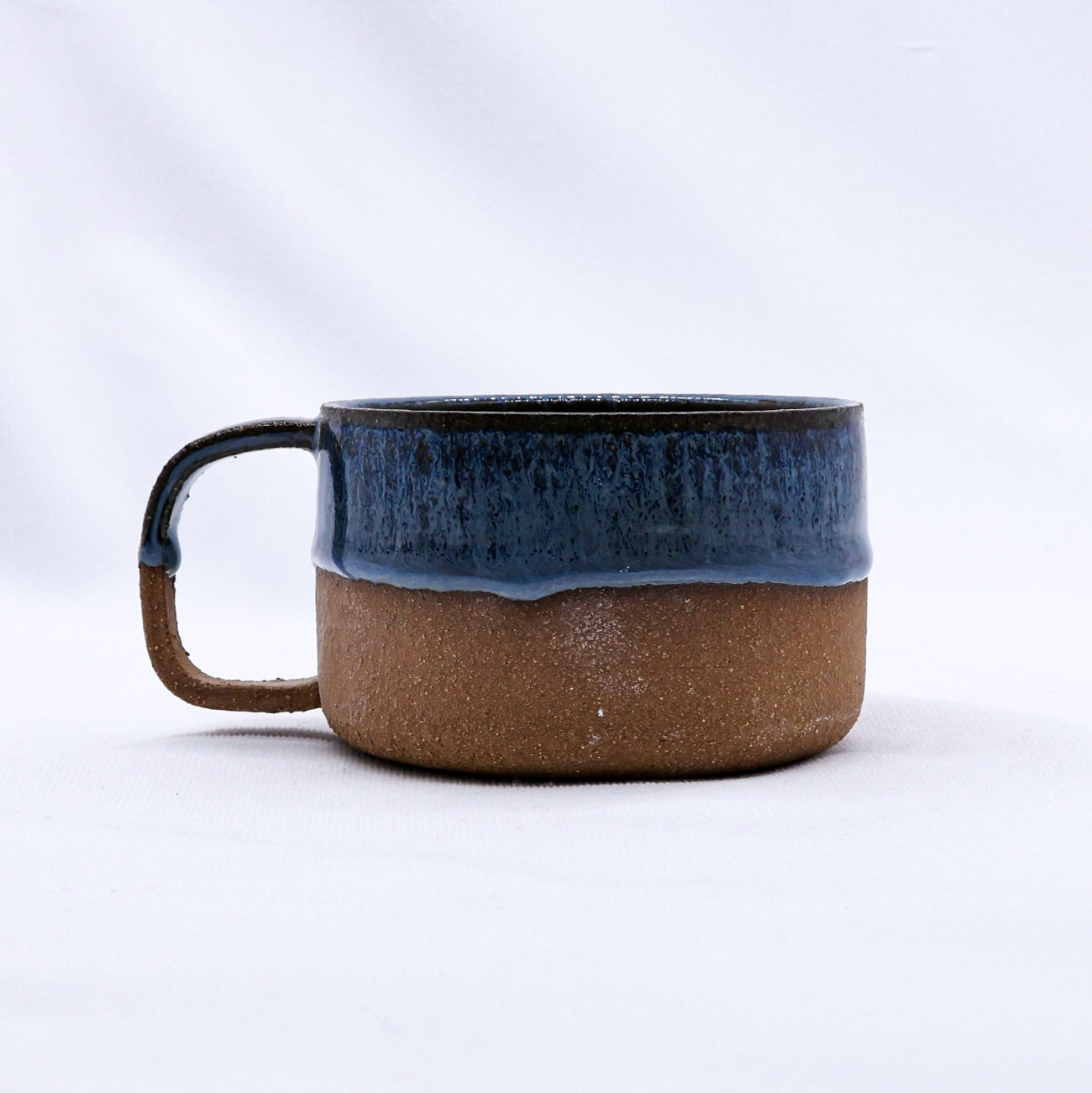 Ceramic mug with blue top and brown bottom on a white background