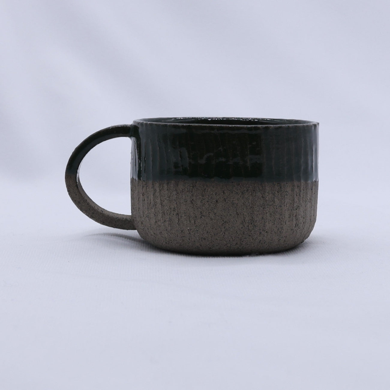 Black ceramic mug on a light gray background
