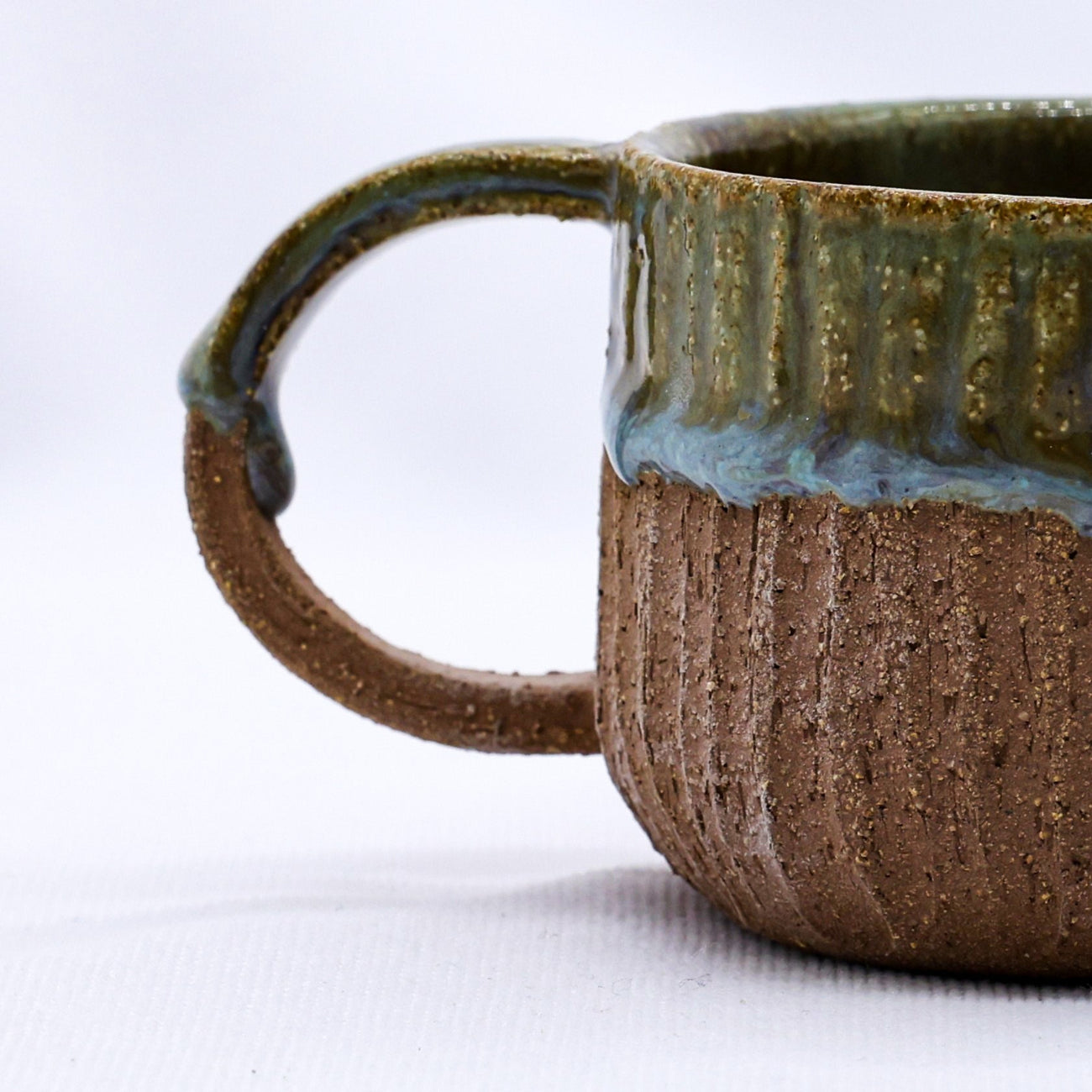 Ceramic mug with textured surface and handle on a white background