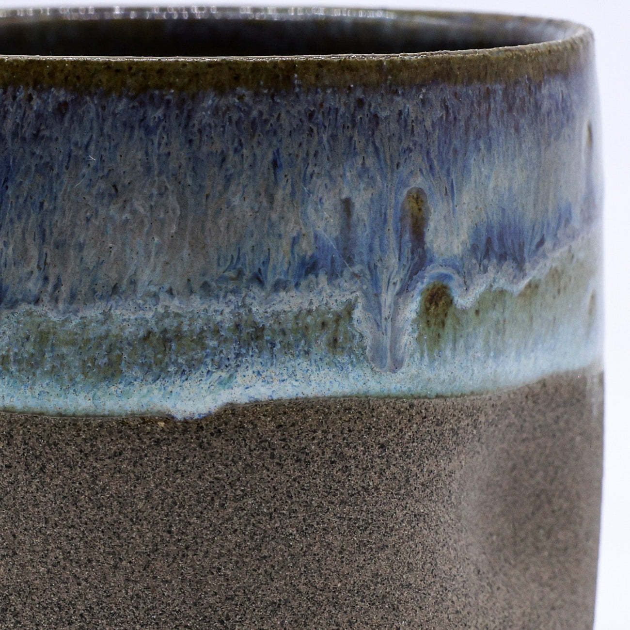 Ceramic cup with a two-tone glaze on a white background