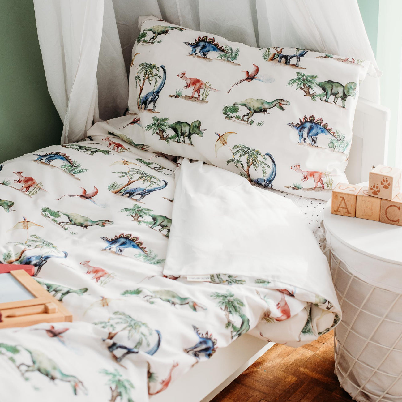 Children's bedroom with dinosaur-themed bedding and canopy.