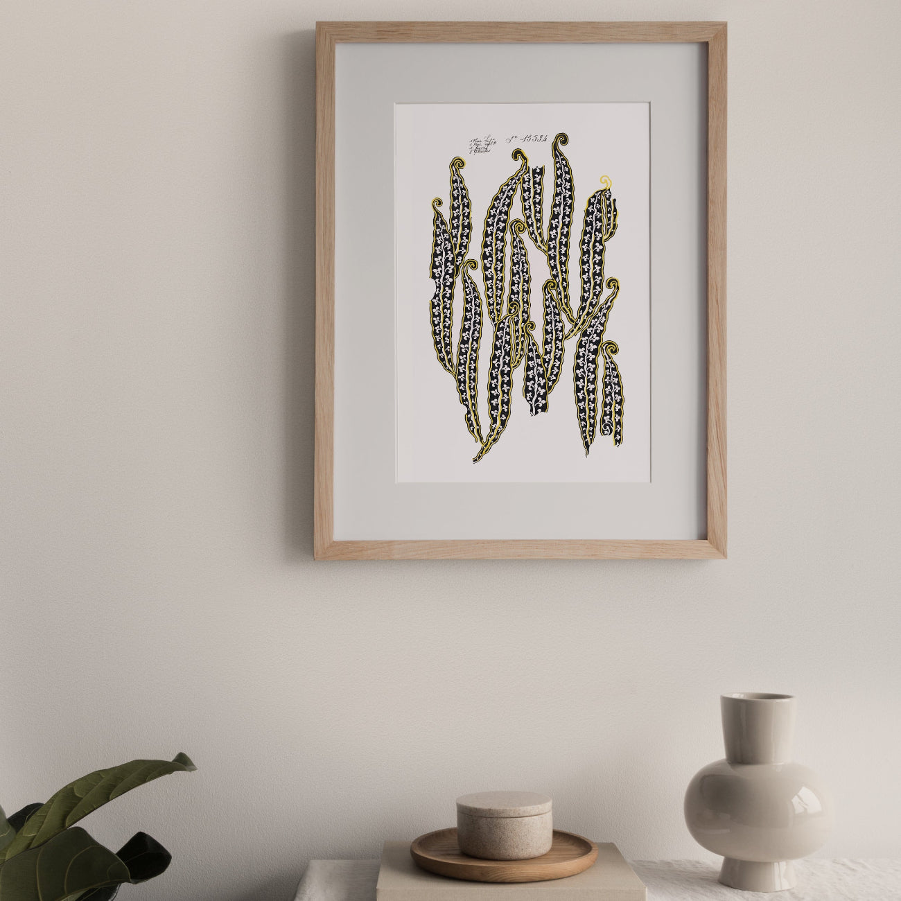 Framed artwork of magic beans on a wall above a table with decor items.