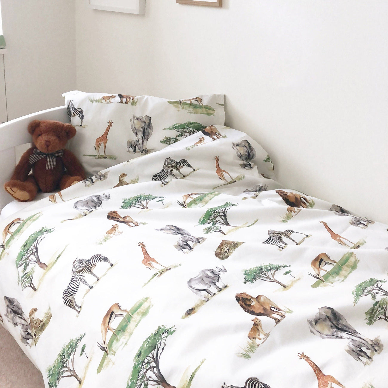 Children's bedroom with animal-patterned bedding and a teddy bear.