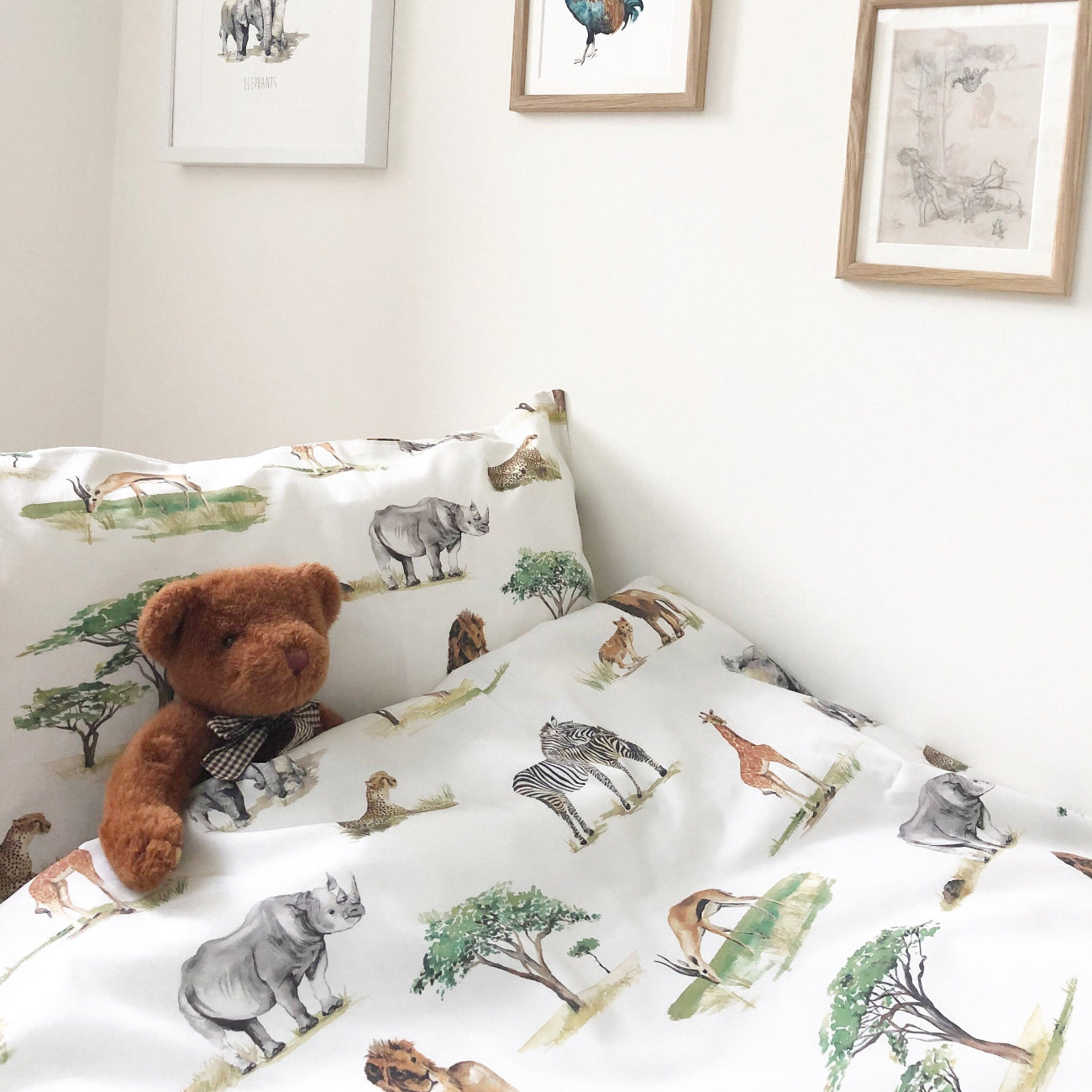 Children's room with animal-patterned bedding and wall art.