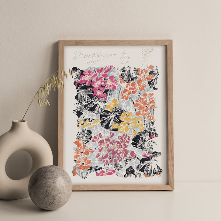 Framed floral art print on a beige wall with decorative elements.
