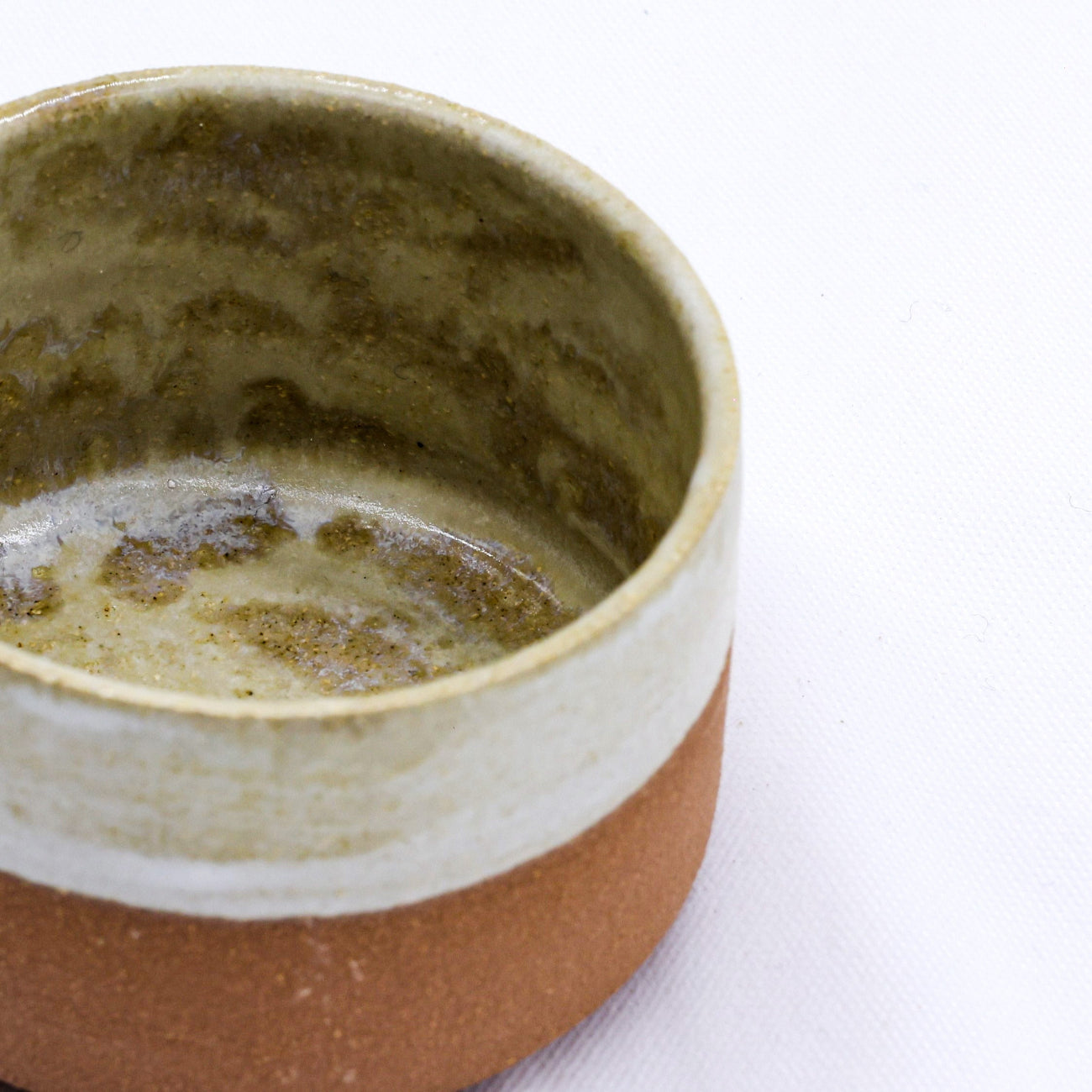 Close-up of a ceramic cup with a textured interior on a white background