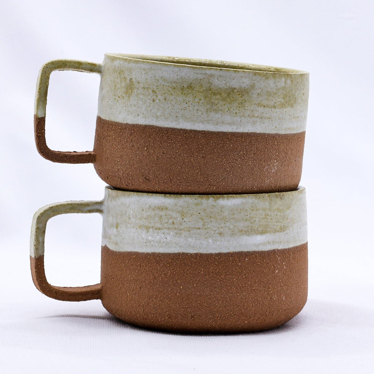 Two ceramic mugs with striped design on a white background
