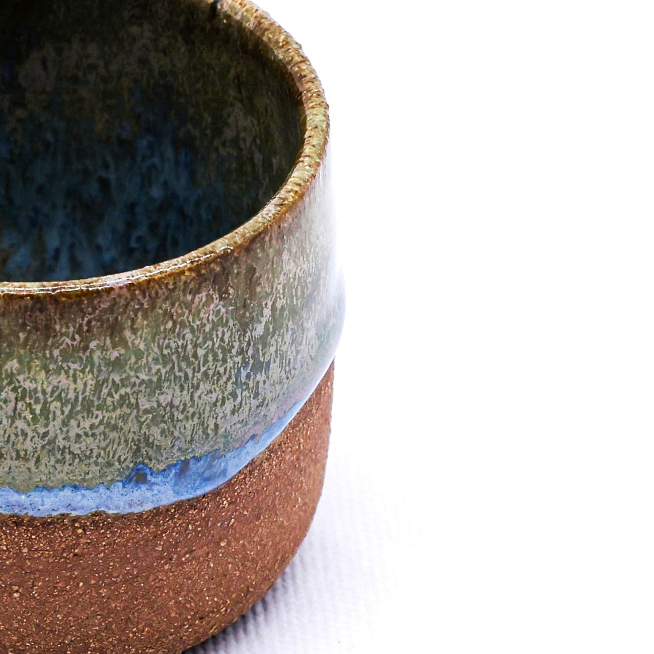 Ceramic espresso cup with multicolored glaze on a white background