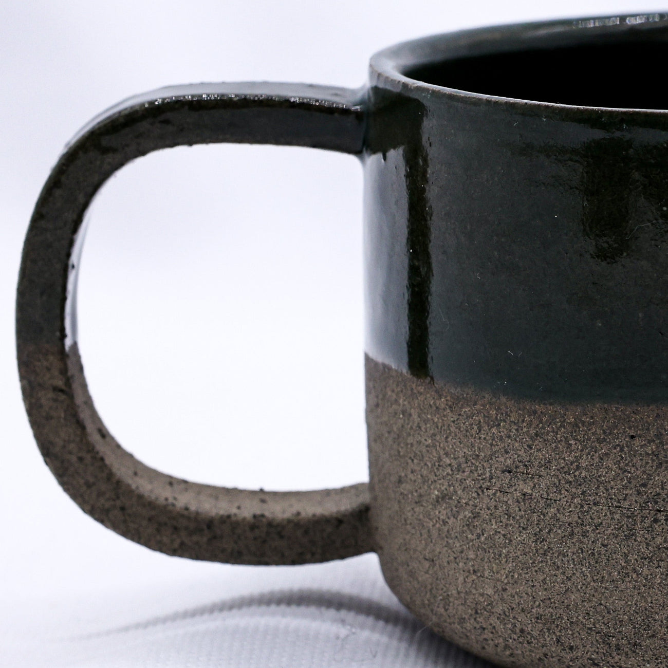 Black ceramic mug with a textured base on a white background