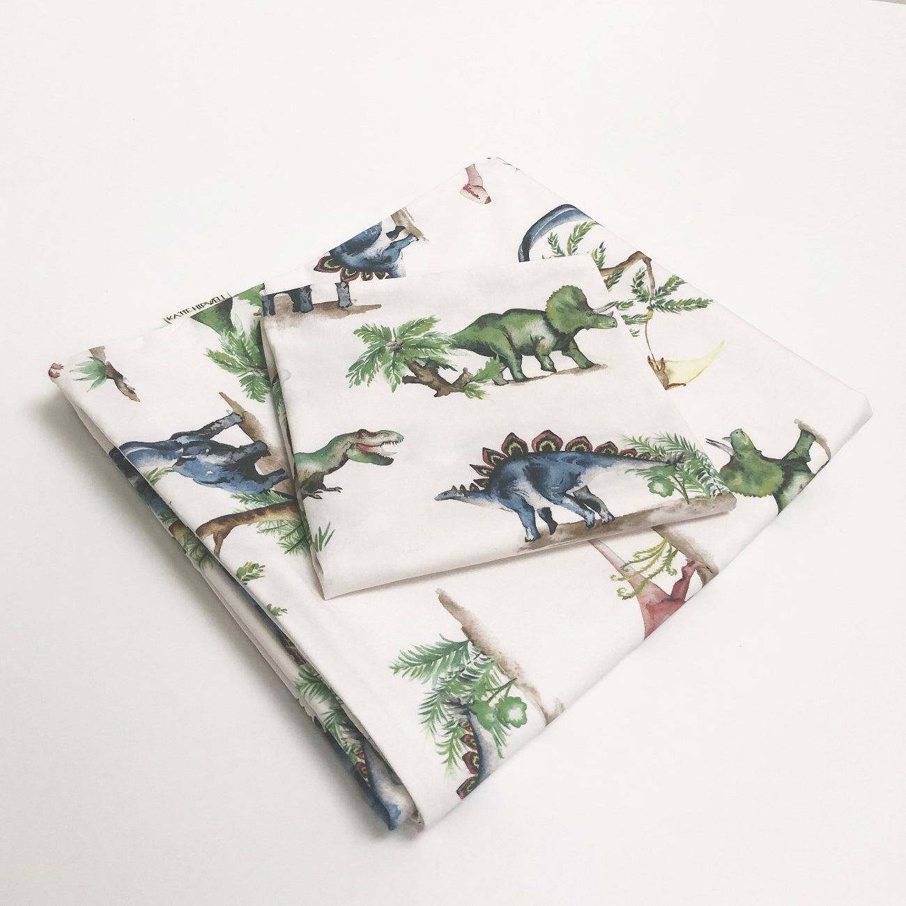 Dinosaur-themed fabric with various dinosaur illustrations on a white background