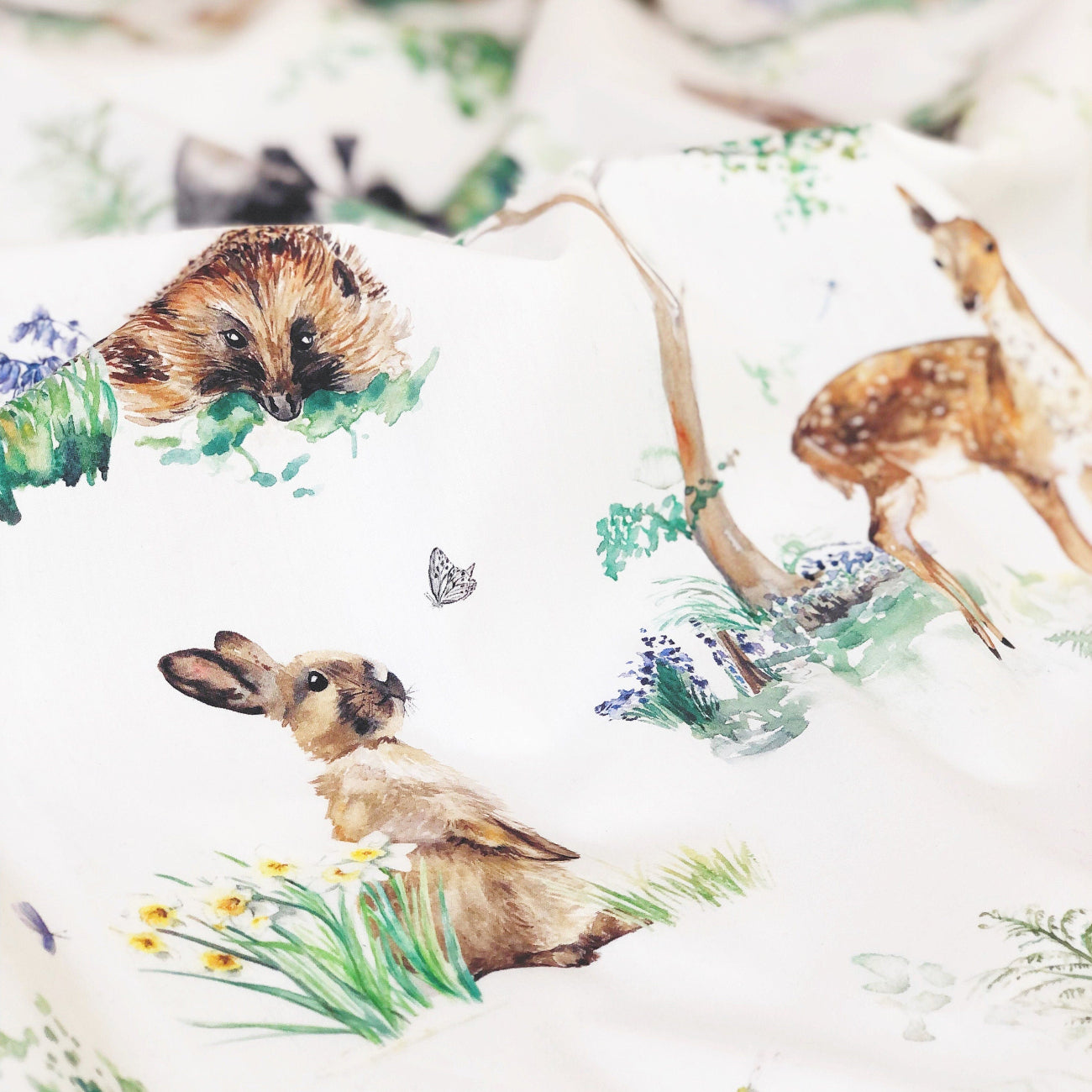 Pattern of hedgehogs, deer, and rabbits with plants on a white background